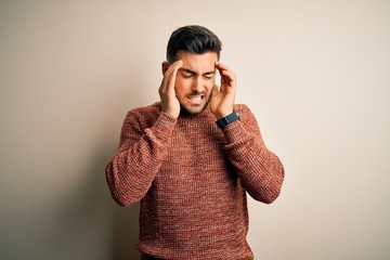 Wall Mural - Young handsome man wearing casual sweater standing over isolated white background with hand on headache because stress. Suffering migraine.