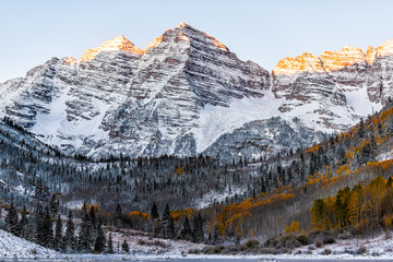 Wall Mural - Maroon Bells morning sunrise sunlight on peaks view in Aspen, Colorado rocky mountain and autumn yellow foliage and winter snow