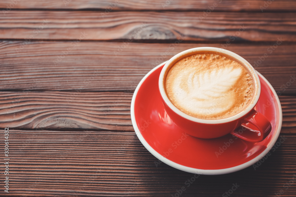Cup of tasty cappuccino on wooden table