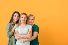 Portrait Of Mature Woman With Her Adult Daughter And Mother On Color Background