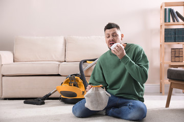 Poster - Man with vacuum cleaner bag suffering from dust allergy at home