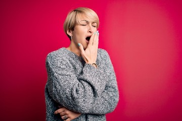 Sticker - Young blonde woman with modern short hair wearing casual sweater over pink background bored yawning tired covering mouth with hand. Restless and sleepiness.