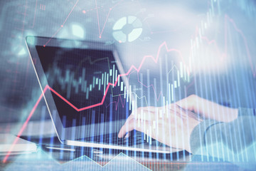 Double exposure of stock market graph with man working on laptop on background. Concept of financial analysis.