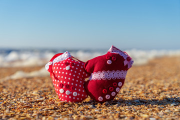 Image of soft toys in the form of mittens on the beach. Handwork.