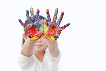 Wall Mural - Portrait of little cheerful girl showing her colorful hands painted. Focus at baby hands.