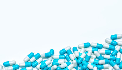 Canvas Print - Pile of antibiotic capsule pills isolated on white background. Global market trends of antimicrobial drugs concept. Antibiotic drug resistance. Pharmaceutical industry. Pharmacy drugstore products.