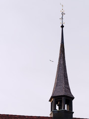 Close-up of bell tower with weather vane at dusk