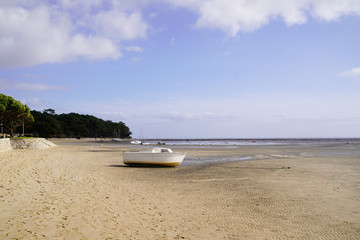 small boat in sand beach at low tide at Ares in Arcachon Bay Gironde department France