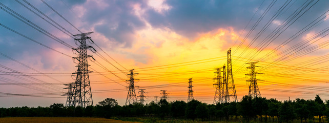 Industrial high voltage electricity tower and beautiful nature landscape at summer sunset