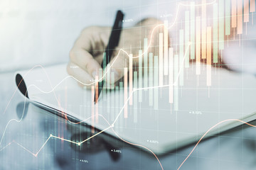 Multi exposure of abstract financial graph with hand writing in notebook on background, financial and trading concept