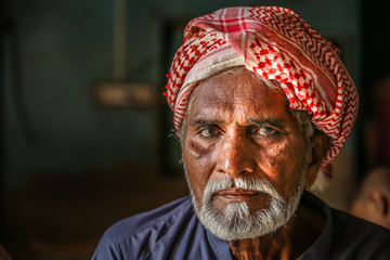 a depressed homeless refugee Arab grandfather wearing traditional turbine and feeling sad