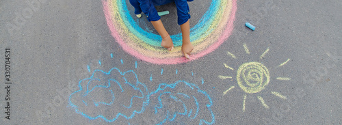 Fotografía child draws with chalk on the pavement. Selective focus.