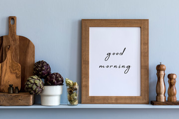 Modern composition on the kitchen interior with mock up photo frame, wooden cutting board, herbs, vegetables and  kitchen accessories in stylish home decor.