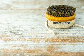 Bamboo beard brush with natural bristles insulated on a wooden base. Facial care concept