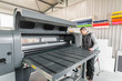 © guruXOX - Electrical engineer operator repairs large industrial printer and plotter machine
