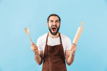 Excited young bearded man cook wearing apron