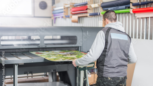 Fotomural Technician operator works on large premium industrial printer plotter machine