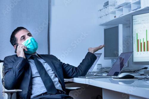 Fotografía Manager in abito si protegge con una mascherina e discute al celliulare seduto n