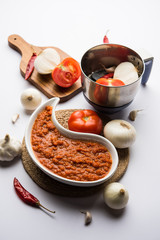 Poster - onion tomato masala or puree for indian gravy, served in a bowl with raw tamatar, pays and lehsun and red chilli, selective focus