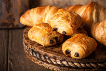 Freshly Baked Sweet Buns Puff Pastry With Chocolate And Croissants On Old Wooden Background. Breakfast Or Brunch Concept With Copy Space.