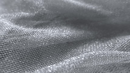 Close-up video of silver net fabric, sparkling small rectangular meshes. Abstract hilly background, shallow depth of field