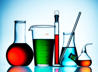 Wall Mural - different laboratory glassware with color liquid and with reflection