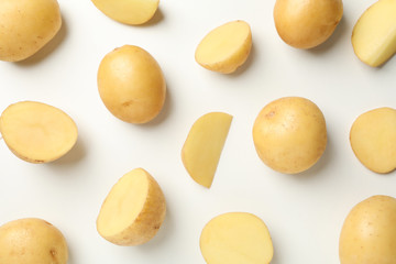 Flat lay with young potato on white background, top view