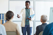 © Seventyfour - Portrait of young African-American man giving speech during meeting with audience, copy space