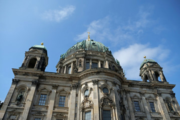 Close-up of upper part of the Berlin cathedral with the cupola with the turquoise copper roof and golden cross on top and two towers; Berlin, Germany, Europe