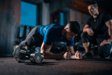 Wall Mural - young man has workout with personal trainer in modern gym