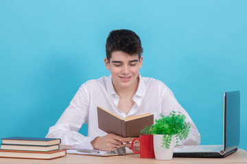 Poster - young male student at desk with book and computer studying