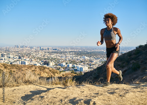 fit african american woman running at 