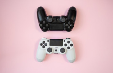 Black and white gamepads on pink background