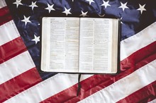 Closeup Shot Of The Bible Open In Pages Put On The American Flag - Perfect For Praying Concept