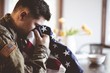 © Ben White/Wirestock - American soldier mourning and praying with the American flag in his hands
