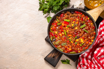 Wall Mural - Chili con carne in skillet on light stone table.