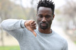 © PheelingsMedia - Black man gesturing thumbs down outdoors