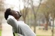 © PheelingsMedia - Black man relaxing on a bench in a park