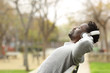 © PheelingsMedia - Black man relaxing on a bench listening to music