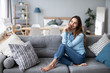 © BestForYou - Relaxed smiling woman sitting on sofa at home.