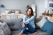 © BestForYou - Happy woman resting comfortably sitting on sofa in the living room at home.