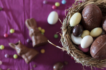 Canvas Print - Top view of bird nest with easter eggs and sweets on table