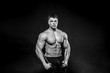 © Andrii - Sexy young athlete posing on a black background in the Studio. Fitness, bodybuilding, black and white