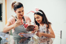 Mother And Daughter Making Homemade Chocolate Easter Eggs. Easter In Brazil.