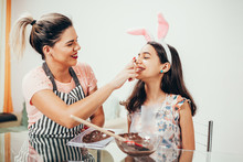 Mother And Daughter Making Homemade Chocolate Easter Eggs. Easter In Brazil.