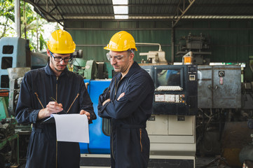 Industrial workers are working on projects in large industrial plants with many devices.