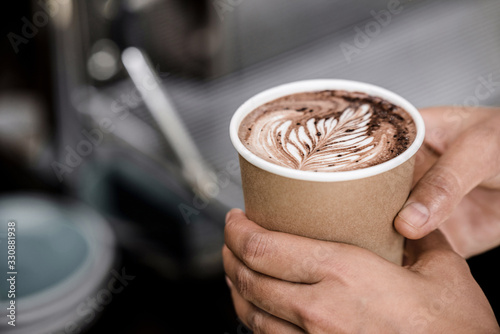 Photographie Close up shot of male hands holding take away cup of brewed hot coffee with Fern