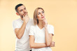 © GVS - Young thoughtful man and woman looking sideways isolated on beige background