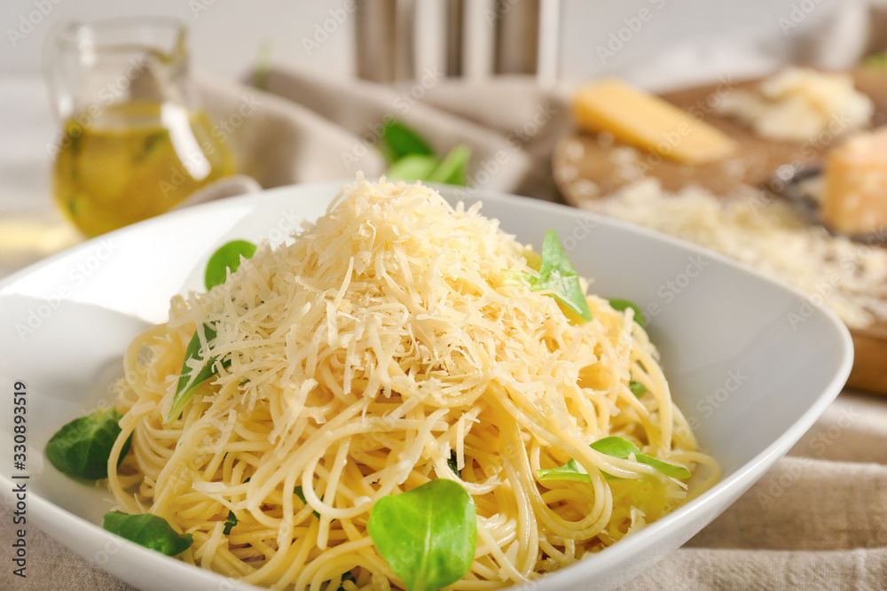 Plate with tasty pasta and cheese on table, closeup