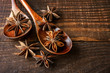 Anise stars in a wooden spoon on a wooden table. Close-up. Food concept